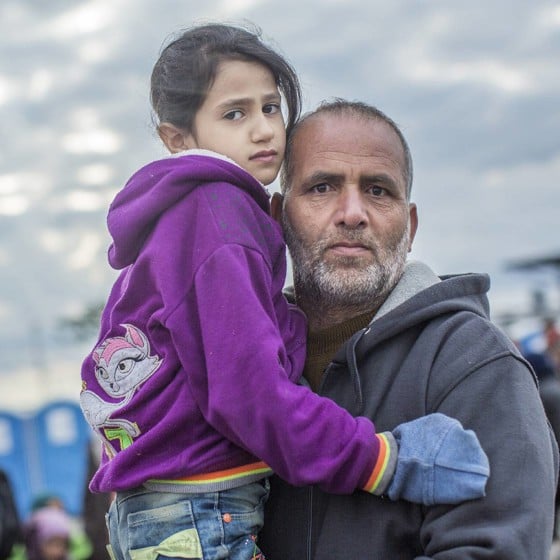 Asylsökande man kramar dotter i lila tröja