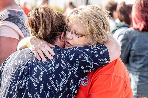 Volontär kramar kvinna drabbad av skogsbränder i Australien.